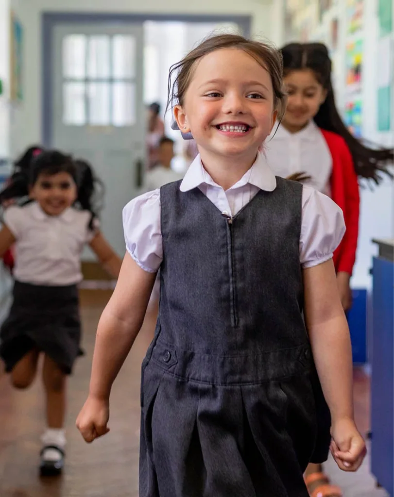 Kid smiling at first day of school with confidence from after orthodontic treatment.