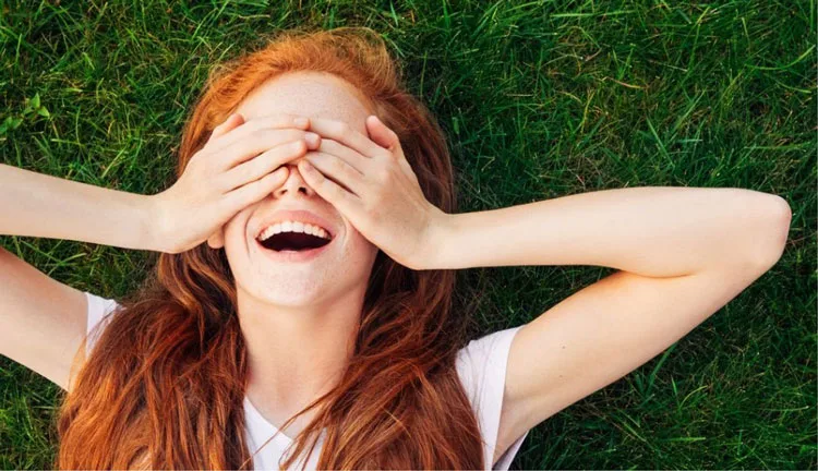 Woman laying down smiling in grass